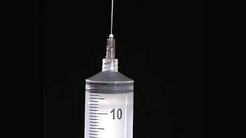 Making of fake tits: filling of expander silicone breast implant with saline into twice its prescribed size