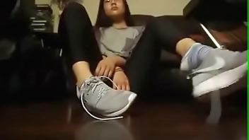Chica asiática se quita los tenis y los calcetines