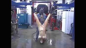 BDSM bitch screams in horror while a man melts a candle on her with a blowtorch